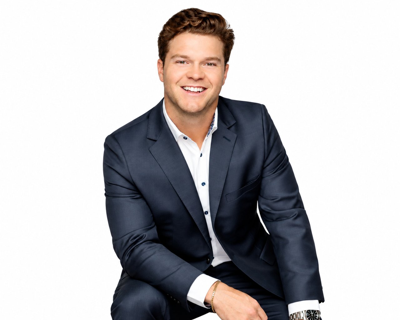 Nick LeBlanc smiling in a navy suit against a white background.