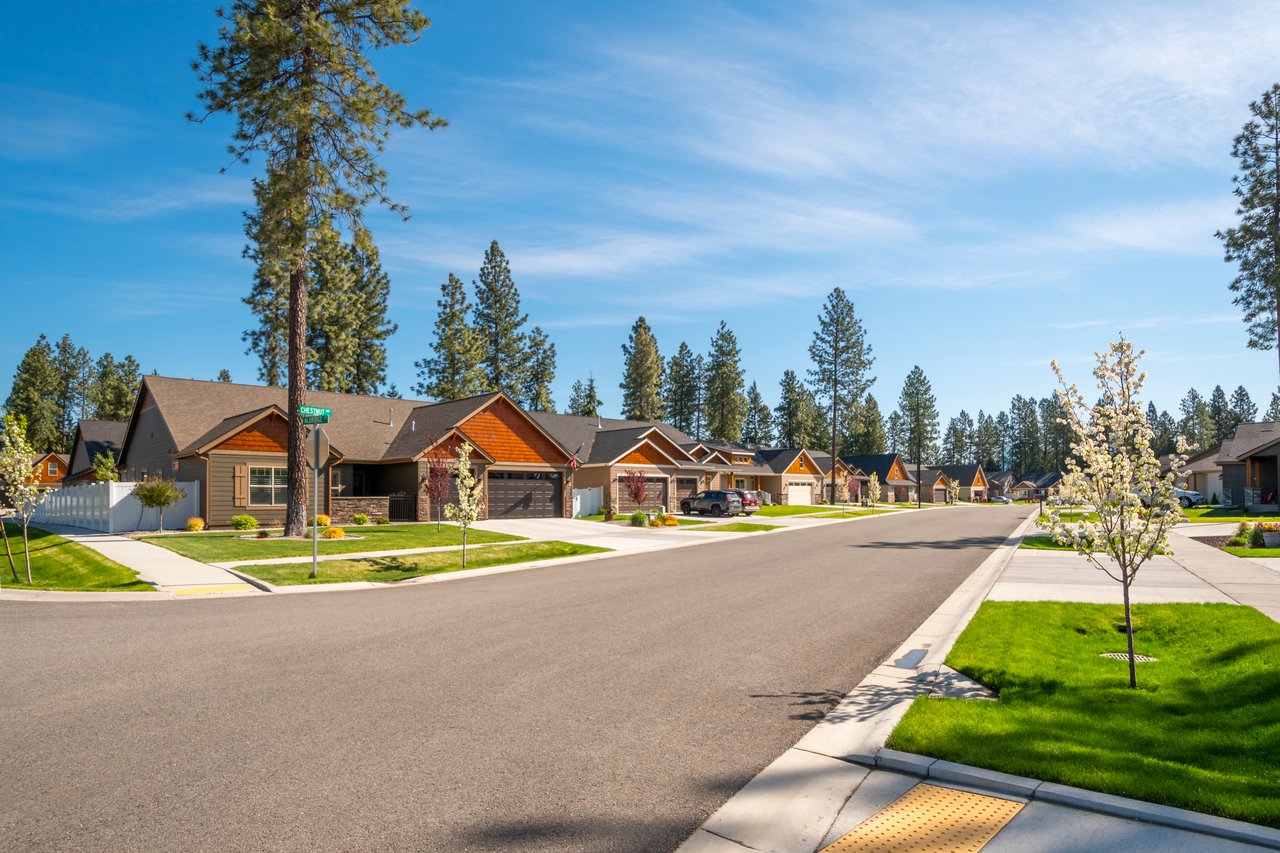 Family walking in a Truckee neighborhood near a top-rated school with mountain homes in the background.
