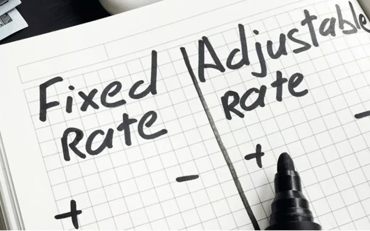 Handwritten comparison of fixed and adjustable mortgage rates with plus and minus signs.