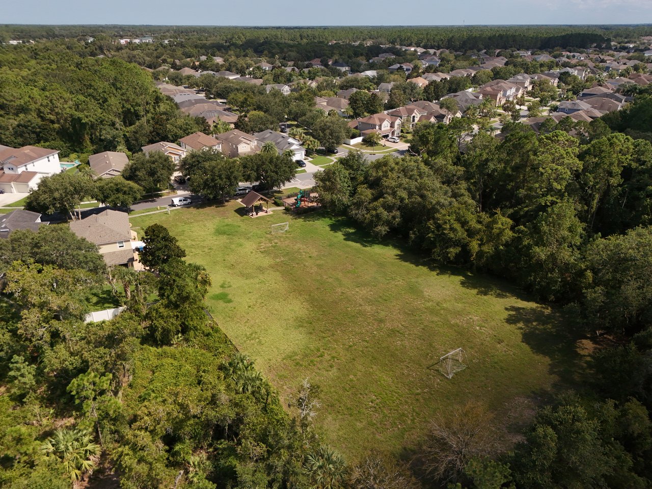 Aerial view of Greenleaf Village homes around a tree-lined grassy field with a small playground.