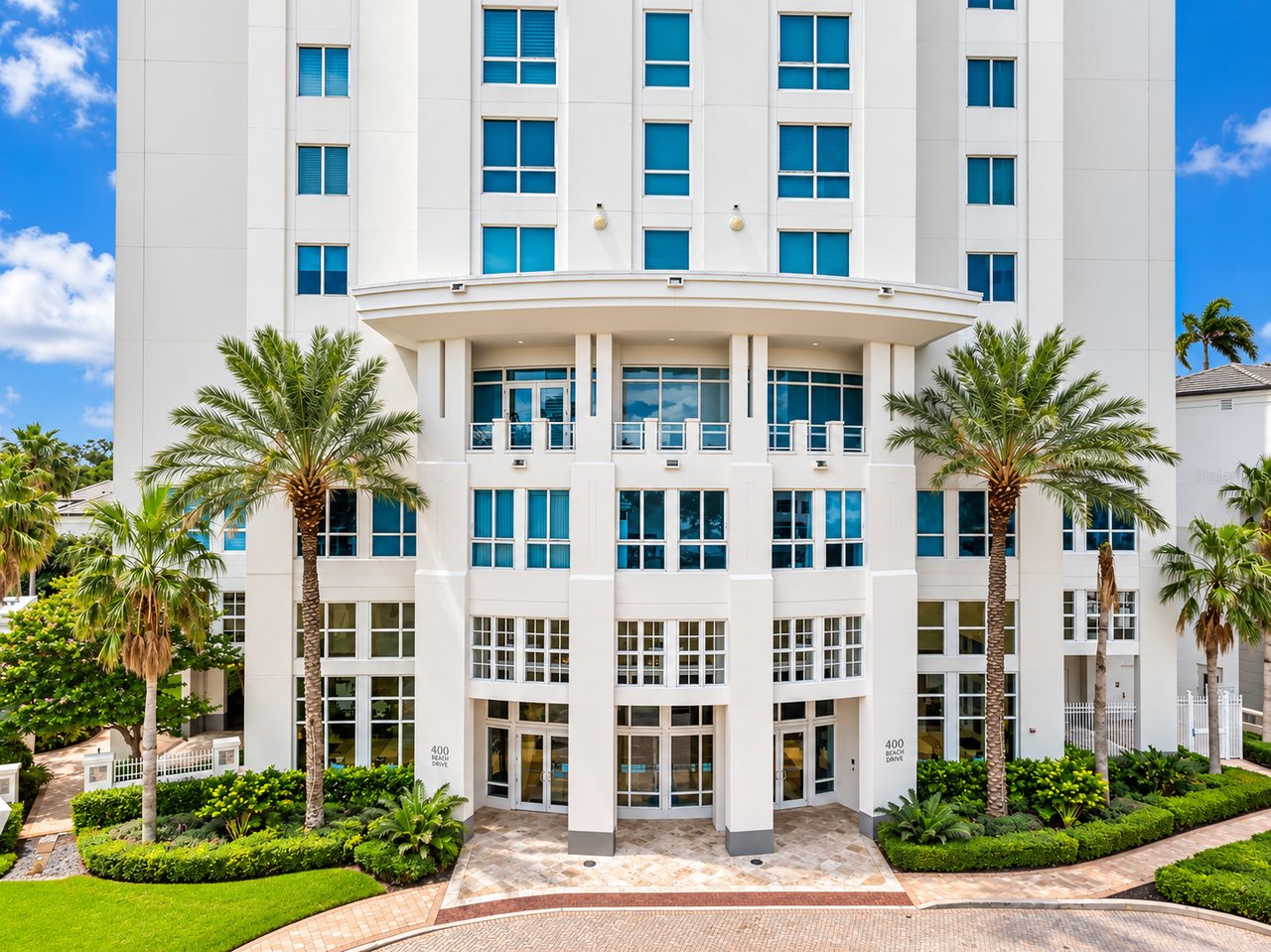 400 Beach Drive condominium building with a curved entrance canopy and palm-lined landscaping.