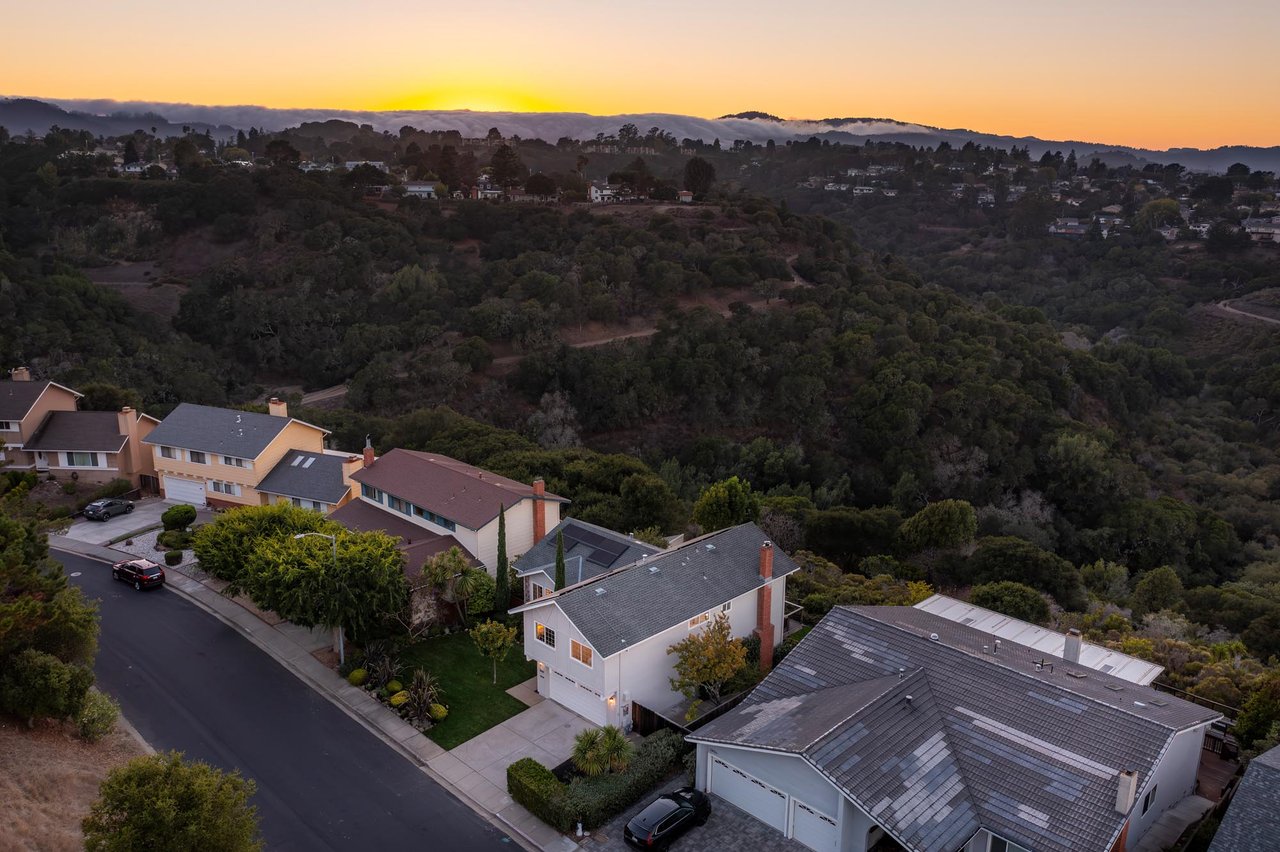 Belmont homes nestled in rolling hills during a golden sunset, with the Bay Area's famous marine layer, "Karl the Fog," visible in the background.