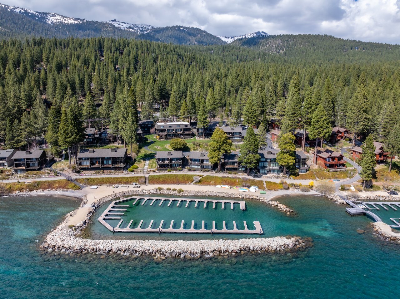 Panoramic view of Lake Tahoe lakefront condos with mountain backdrop, representing Lake Tahoe homes for sale