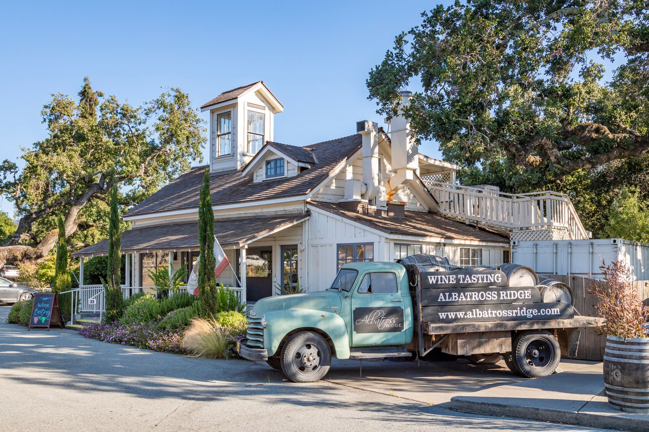 Albatross Ridge wine tasting room with a vintage turquoise truck and wine barrels outside.