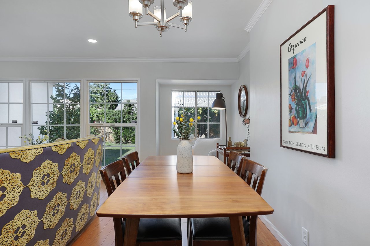 Stylish reading nook with white chair, mid-century bar cart, and garden views through large window