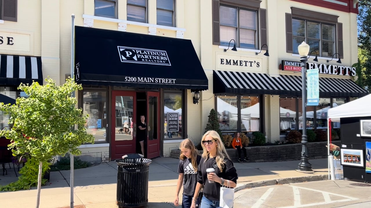 Downtown Downers Grove, Illinois, featuring the Platinum Partners Realtors office at 5200 Main Street, neighboring businesses, and pedestrians.