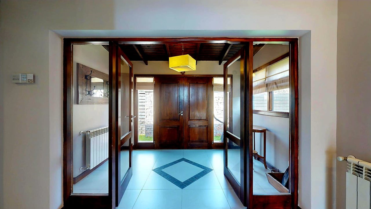 Entry hall with dark wood double doors, glass sidelights, and a blue geometric tile floor.