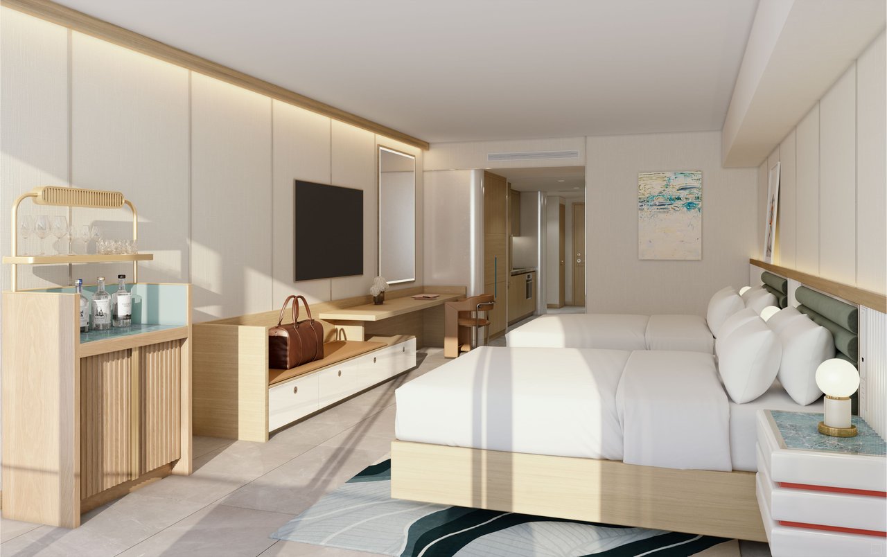 Furnished bedroom with a king bed, built-in desk, and minibar cabinet.