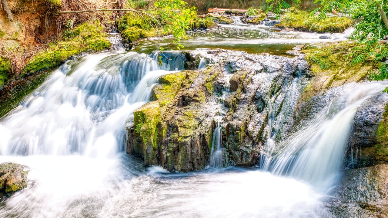 Water cascading over mossy rocks at Savannah Rapids Park in Martinez, Columbia County, Georgia