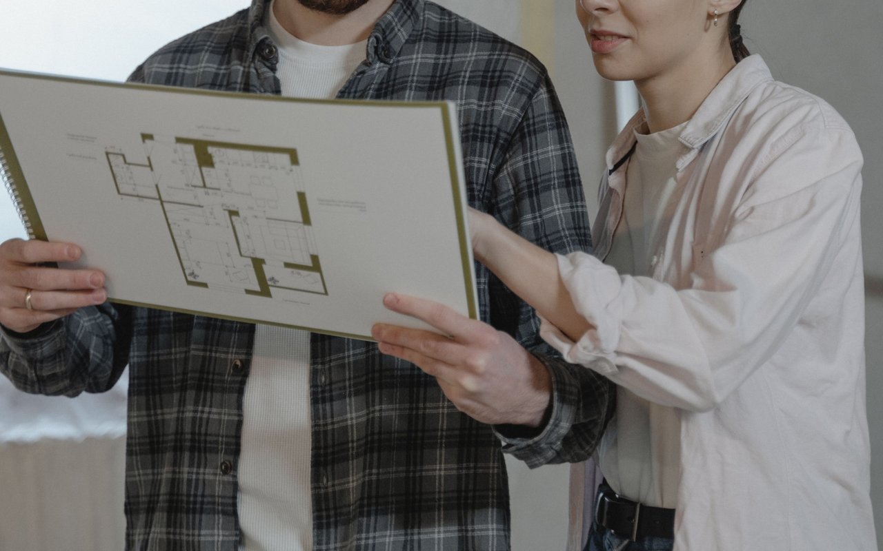 Couple reviewing a house floor plan together.