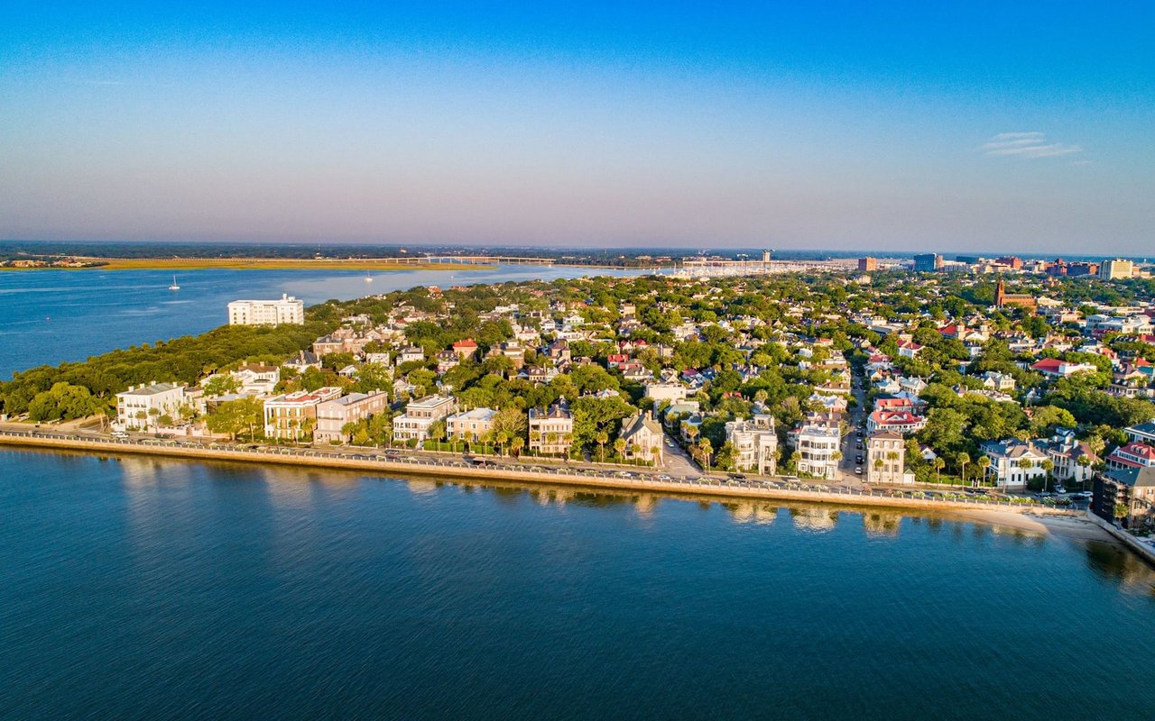 Aerial view of a tree-lined coastal city waterfront and harbor.