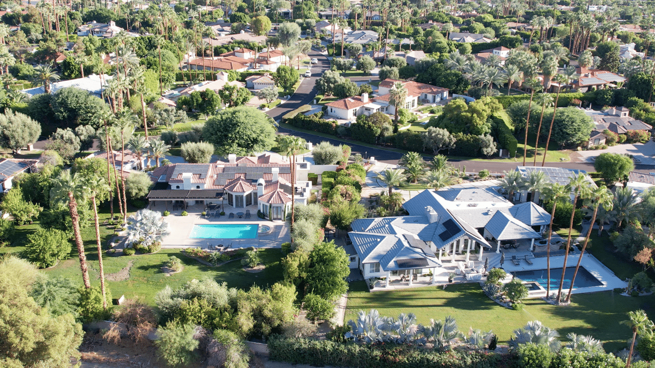 Aerial view of Rancho Mirage homes with palm trees, swimming pools, and lush desert landscaping in Rancho Mirage, California.