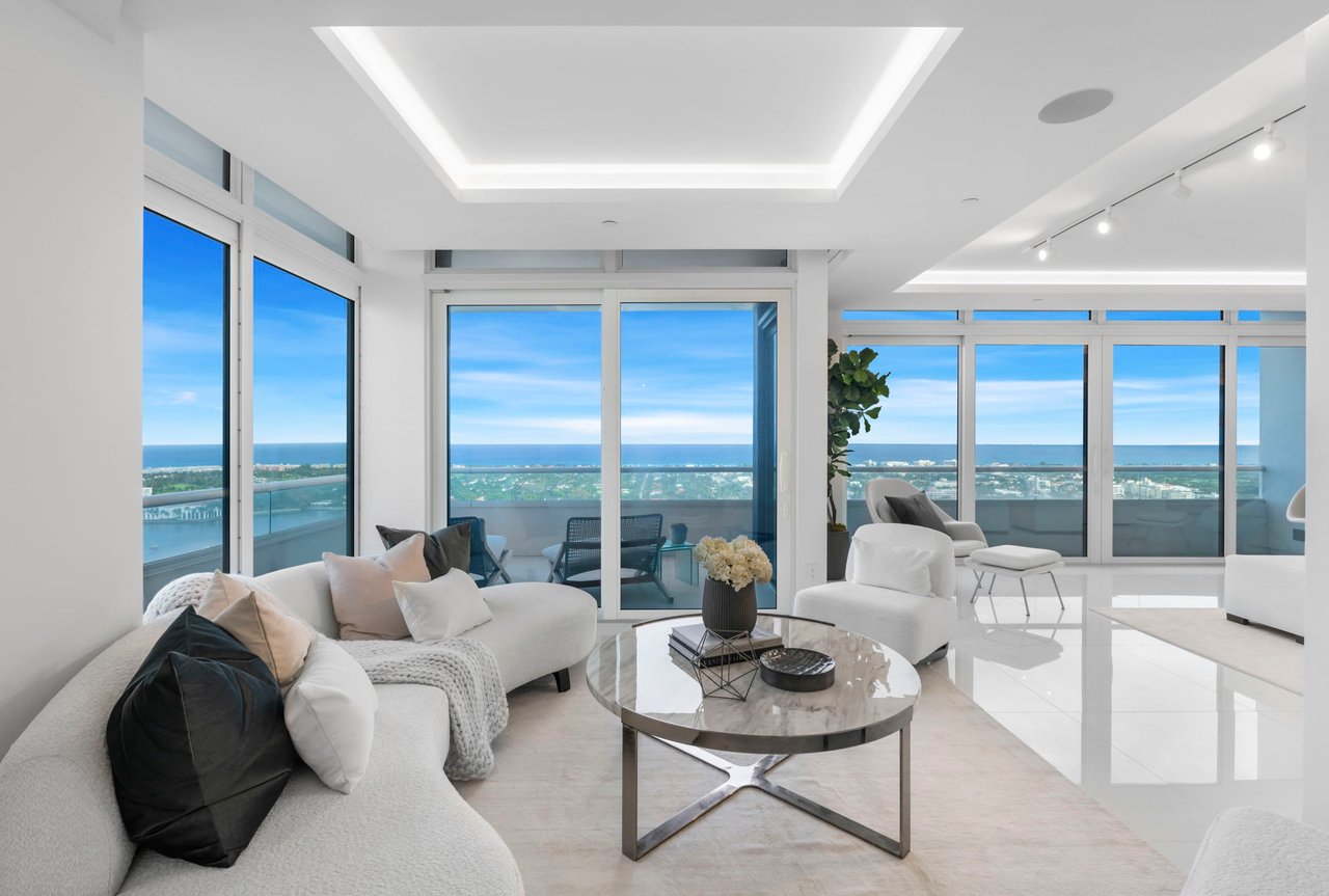 Modern living room with balcony overlooking blue skies, ocean and Palm Beach Island