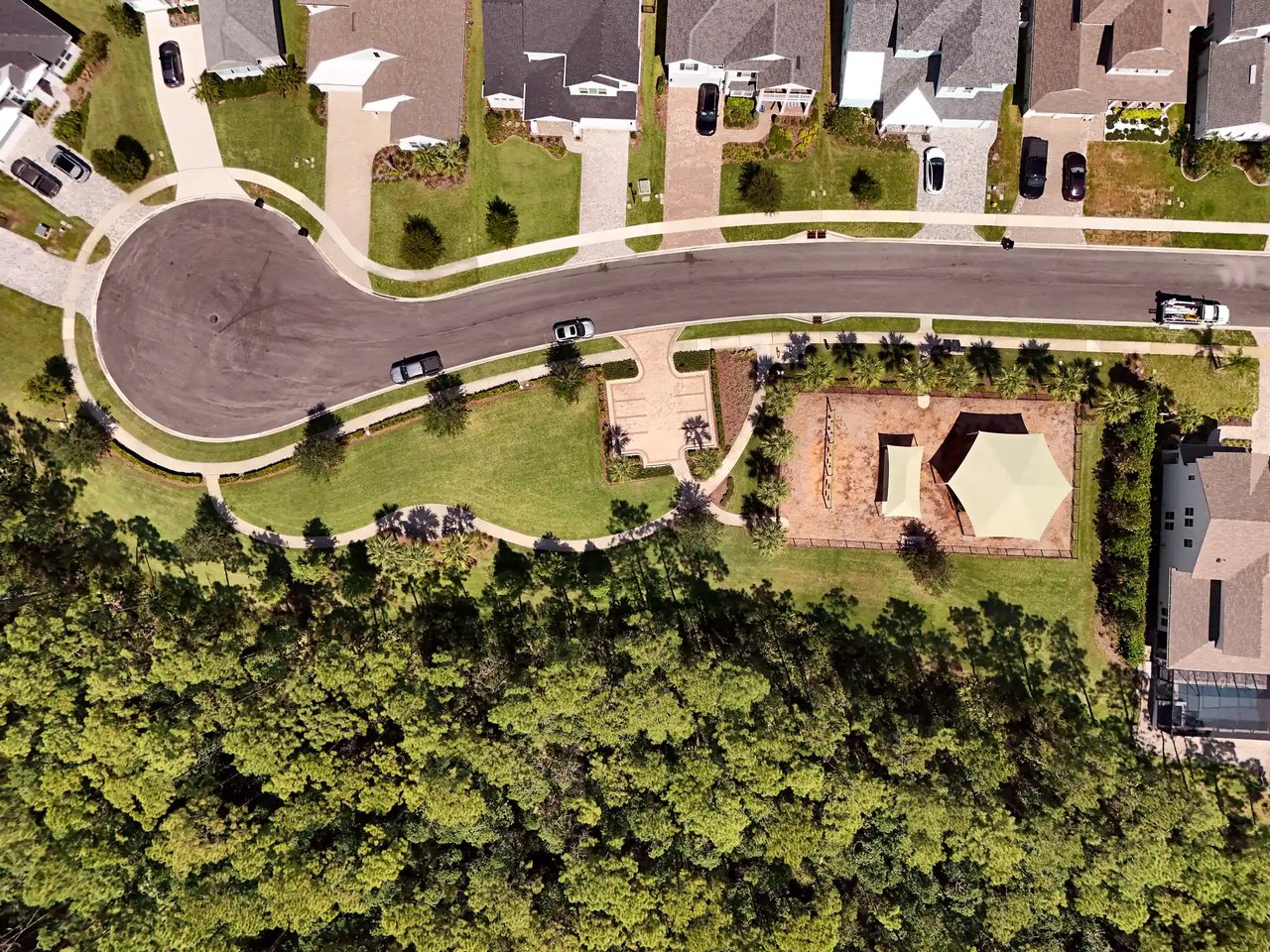 Top-down aerial view of a Palm Crest cul-de-sac, homes and a shaded playground bordered by preserve.