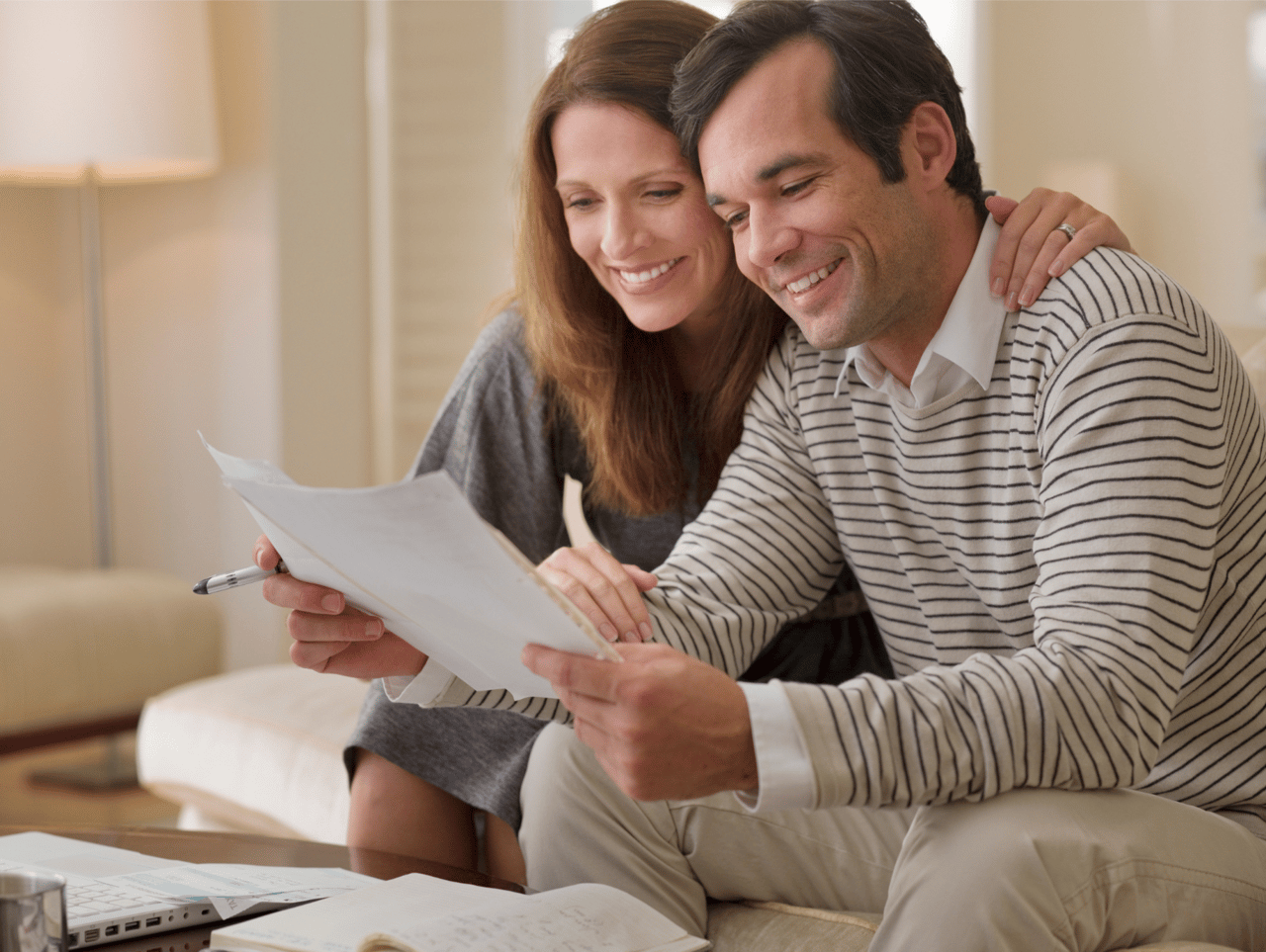 Homebuyers reviewing financial documents while preparing to purchase a home