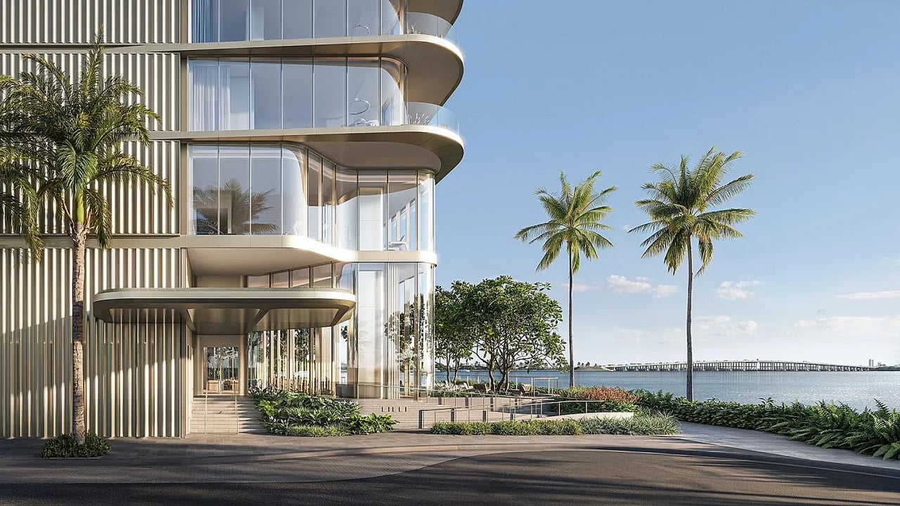 LILLI waterfront residential building with curved glass balconies, palm trees, and a bridge across the bay.
