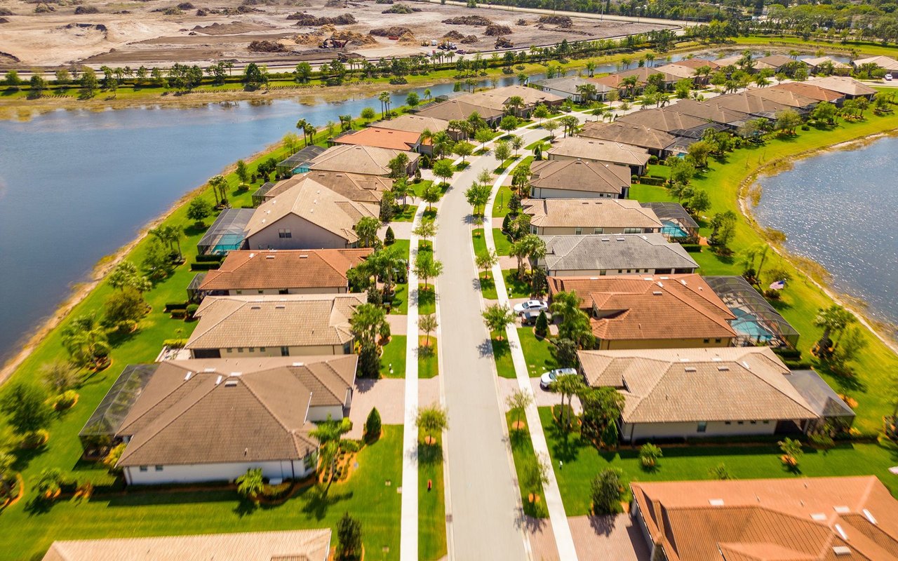 Aerial view of homes along a curving street between two waterways.
