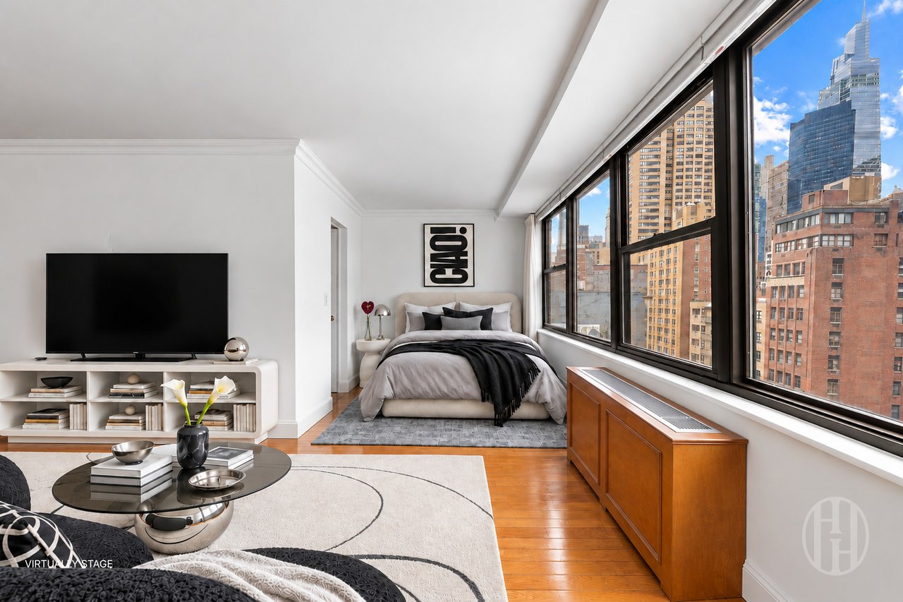 Virtually staged bedroom and living area with large windows overlooking the Manhattan skyline.
