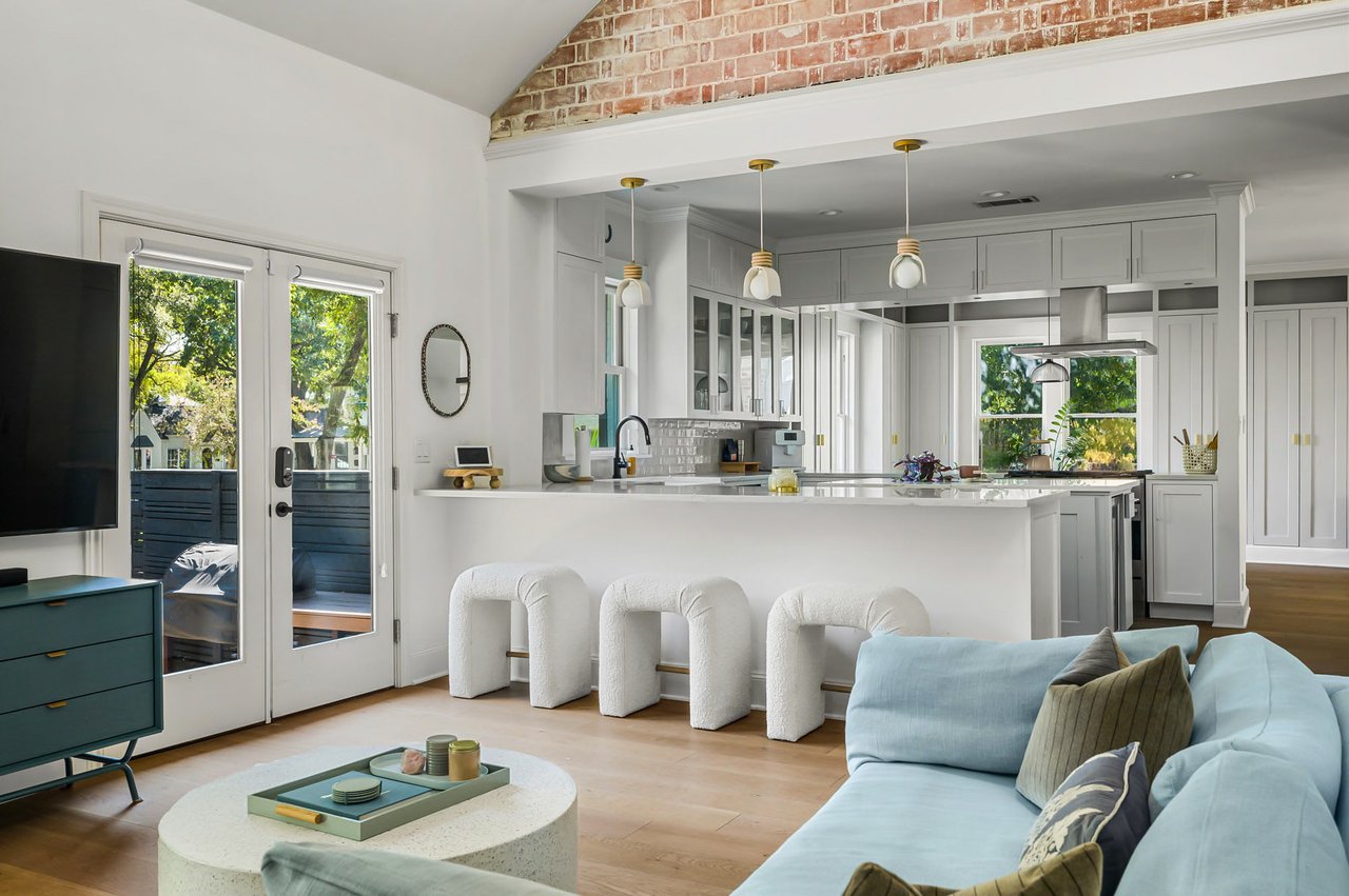Two-story family room with brick accent wall, open to kitchen, at 1500 Northwood Rd, Pemberton Heights, Austin. Renovation by McWalters Collaborative.