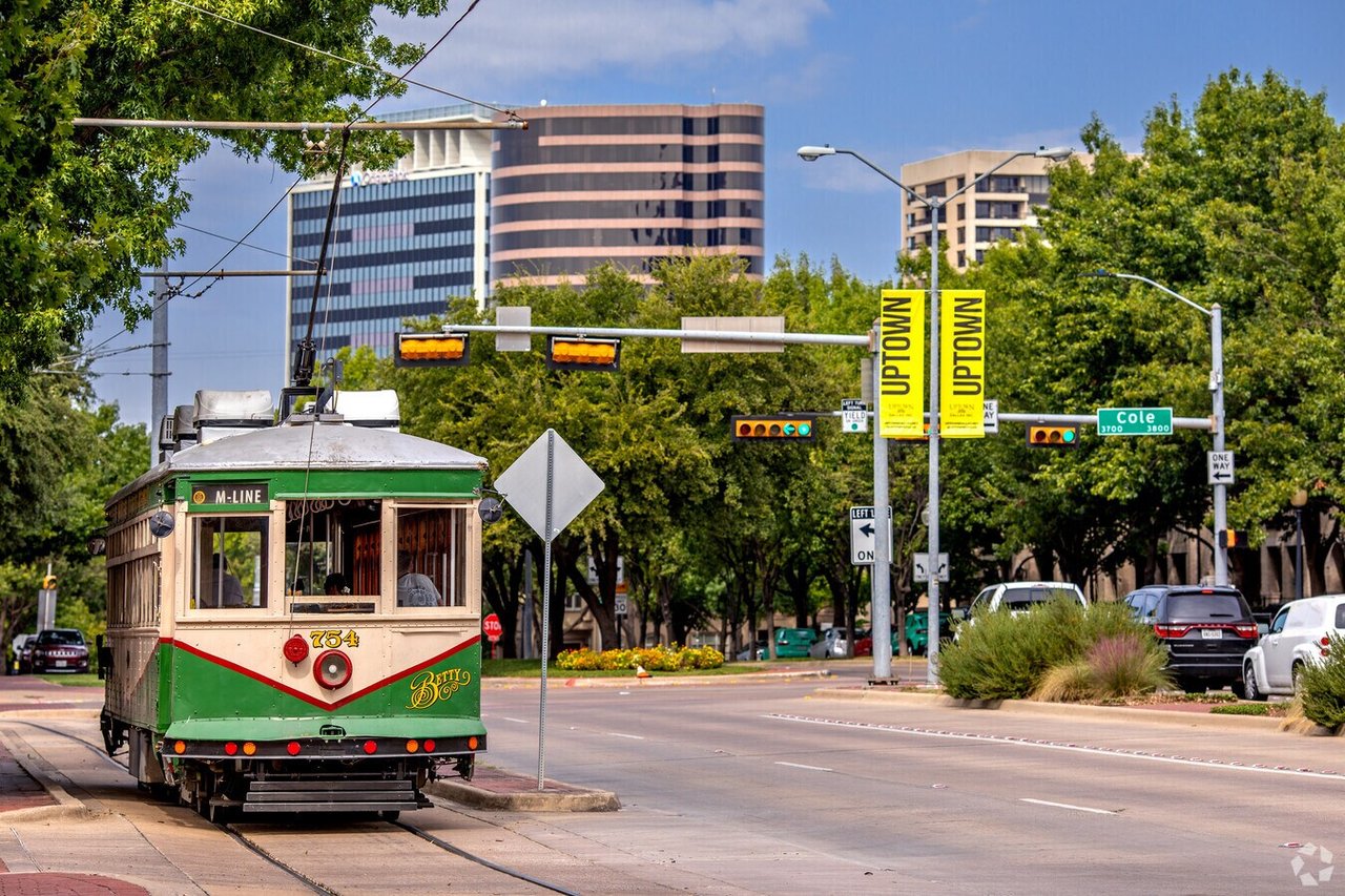 M-Line trolley at a Dallas Uptown intersection, with Uptown banners and office buildings.