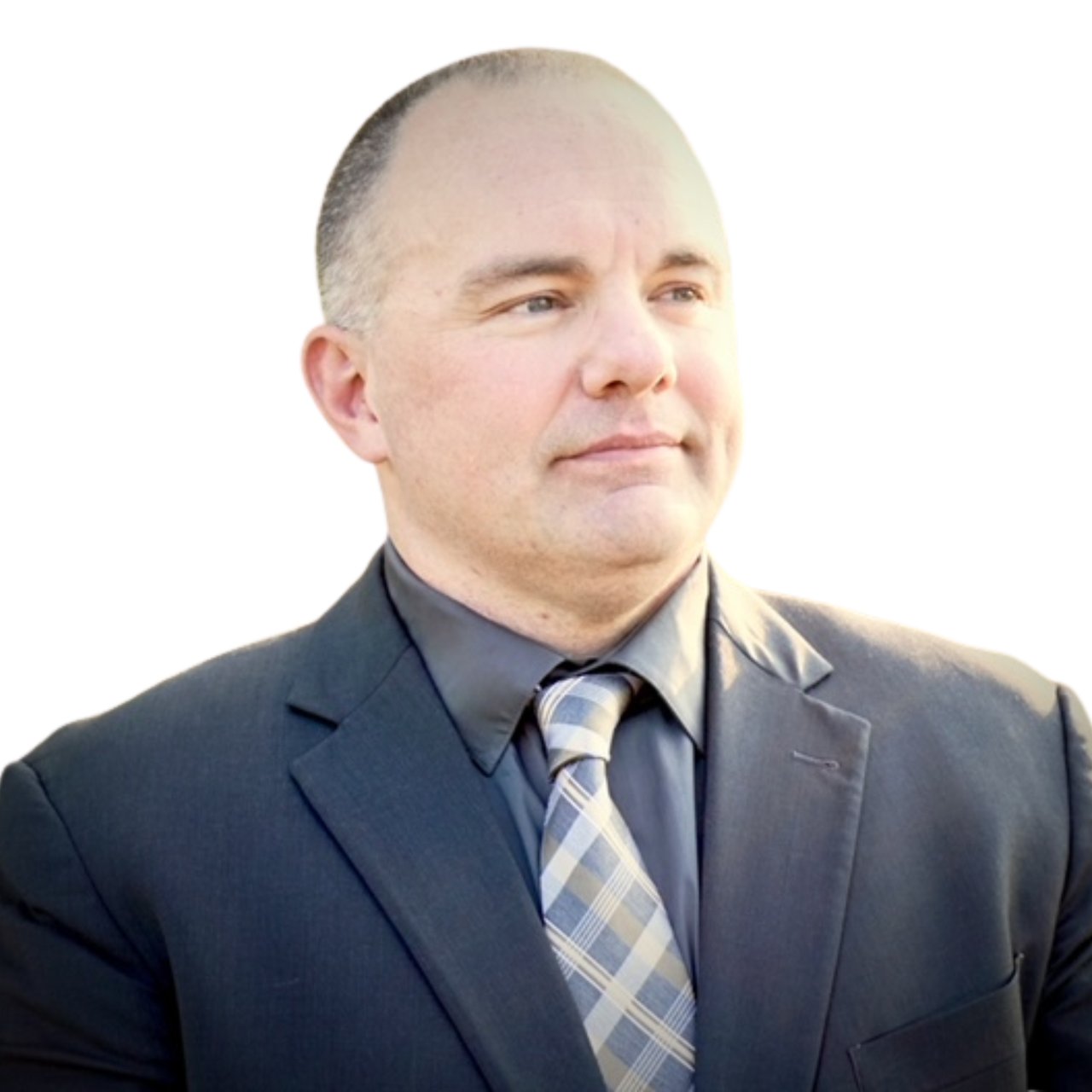 Blake Lycett in a dark suit and plaid tie, looking off to the side.