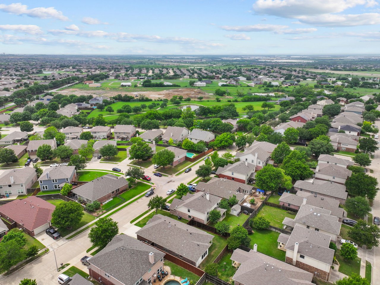 Harvest Ridge from above, upscale residential neighborhood under a blue sky. This DFW real estate image highlights the serene, amenity-rich environment available for home buyers in the Fort Worth area, including Haslet, Roanoke and Keller. Image provided by Carter Signature Properties.