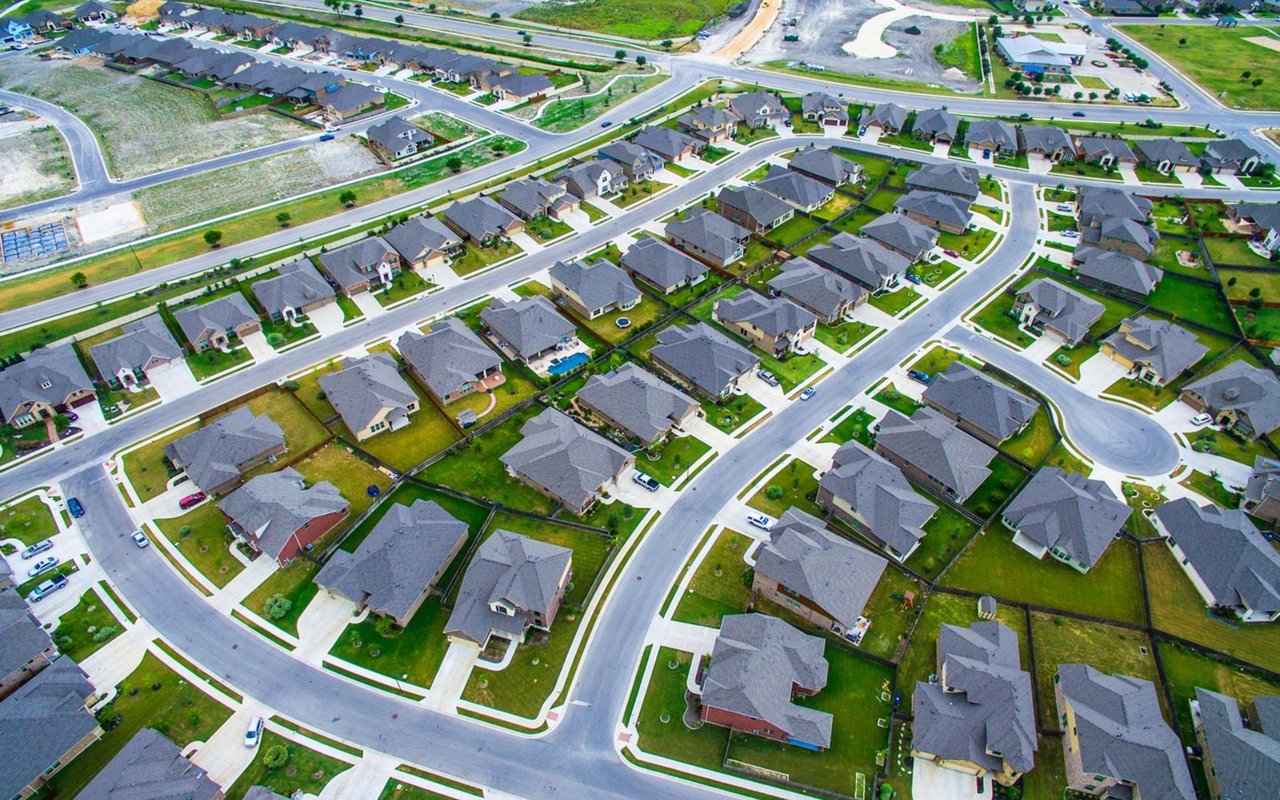 Aerial view of a suburban neighborhood with closely spaced homes and curving streets.