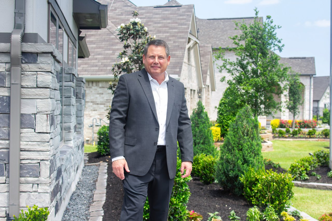 Keith Rodgers REALTOR standing in front of new construction homes.