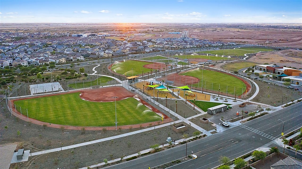 Aerial view of a neighborhood park with baseball fields and playground equipment beside surrounding homes.