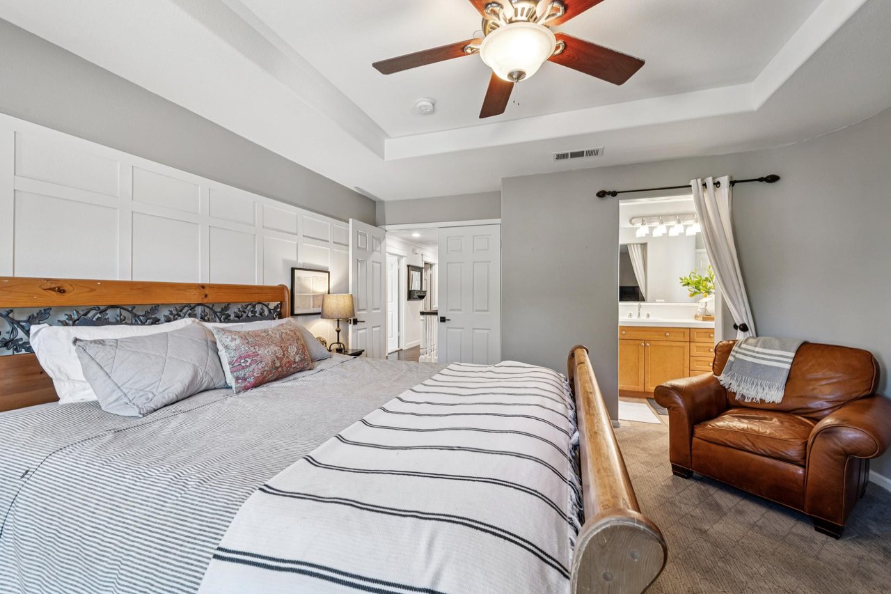 Comfortable bedroom with large windows, natural light, and sophisticated design details.