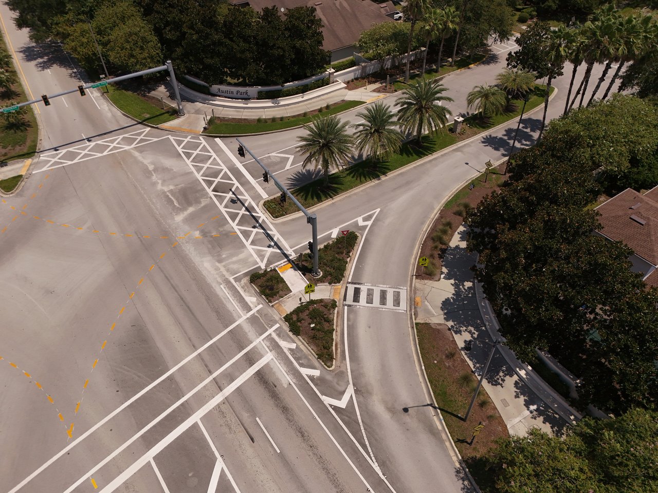 Aerial view of Austin Park’s palm-lined entrance and landscaped median.