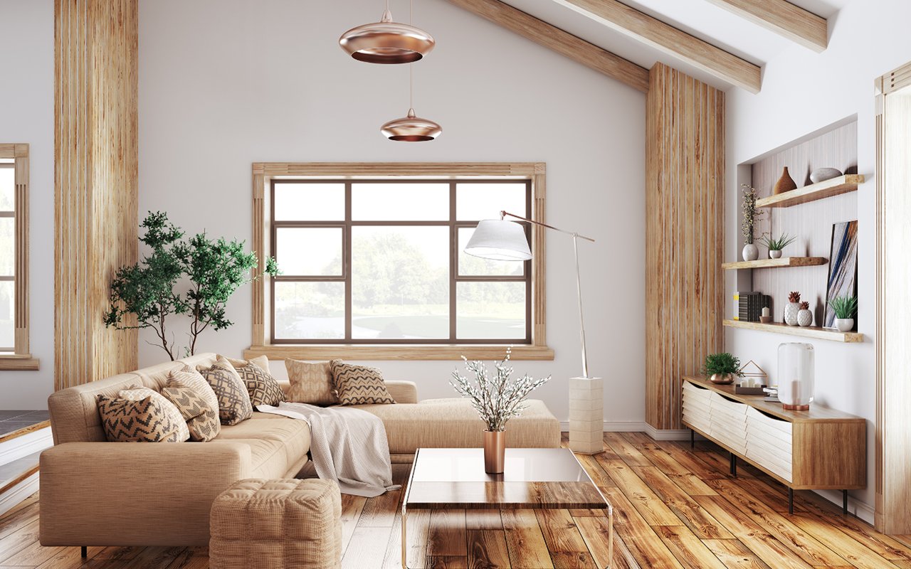 Staged living room with a beige sectional, wood floors, exposed beams and large windows.