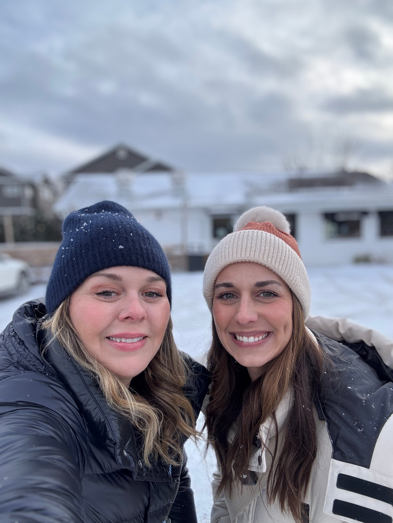 Cait Berry and Ashlee Aplin, of Insiders Realty, standing in front of Branch + Daughter, a popular neighborhood café in Windsor, WI.