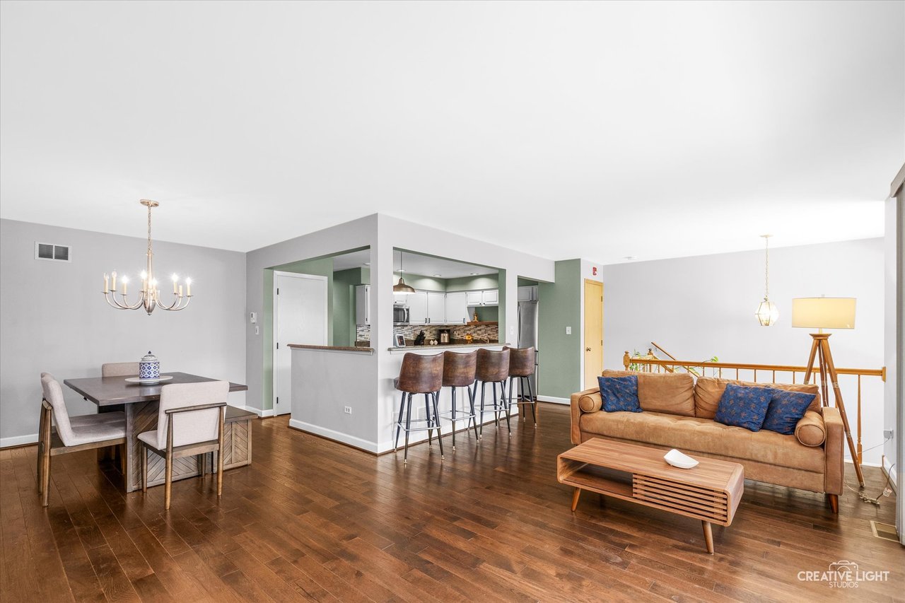 Hardwood floor living room with south facing balcony doors at 8316 Woodland Drive Darien IL
