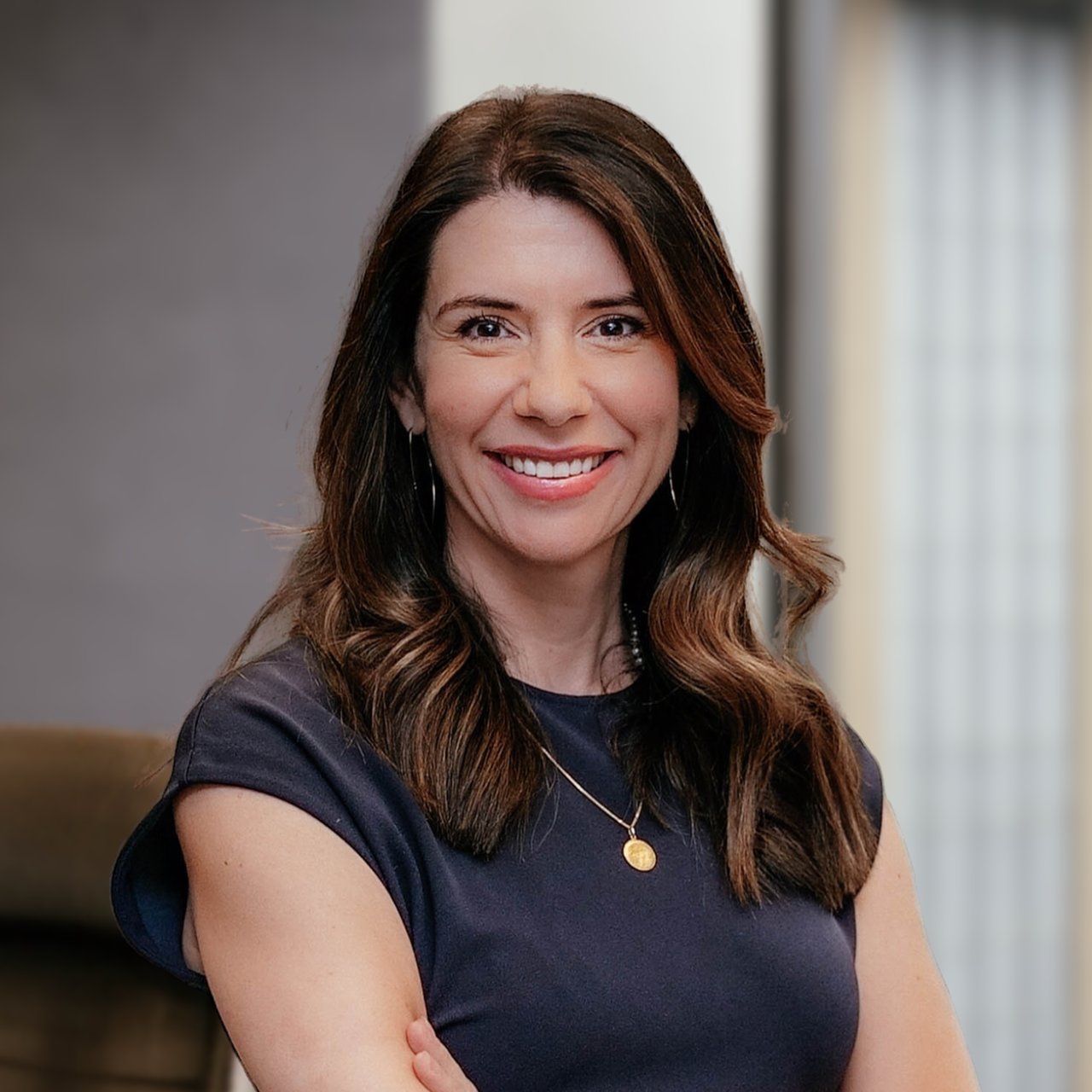 Teresa Stephenson smiling with her arms crossed in a navy top.