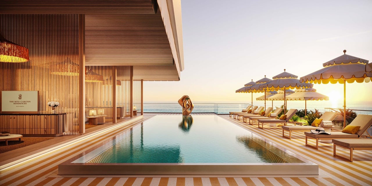 Pool at The Ritz-Carlton Residences, South Beach, with ocean views and striped loungers at sunset.