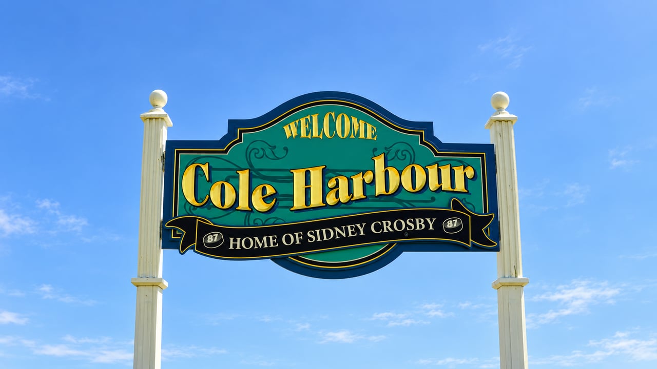 Cole Harbour welcome sign with “Home of Sidney Crosby” banner against a blue sky.