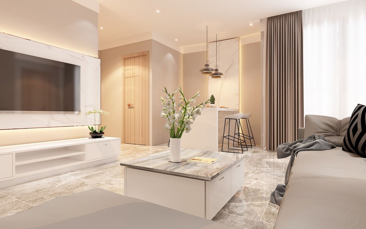 Staged living room with a marble-look TV wall, stone coffee table, and open kitchen with bar stools.