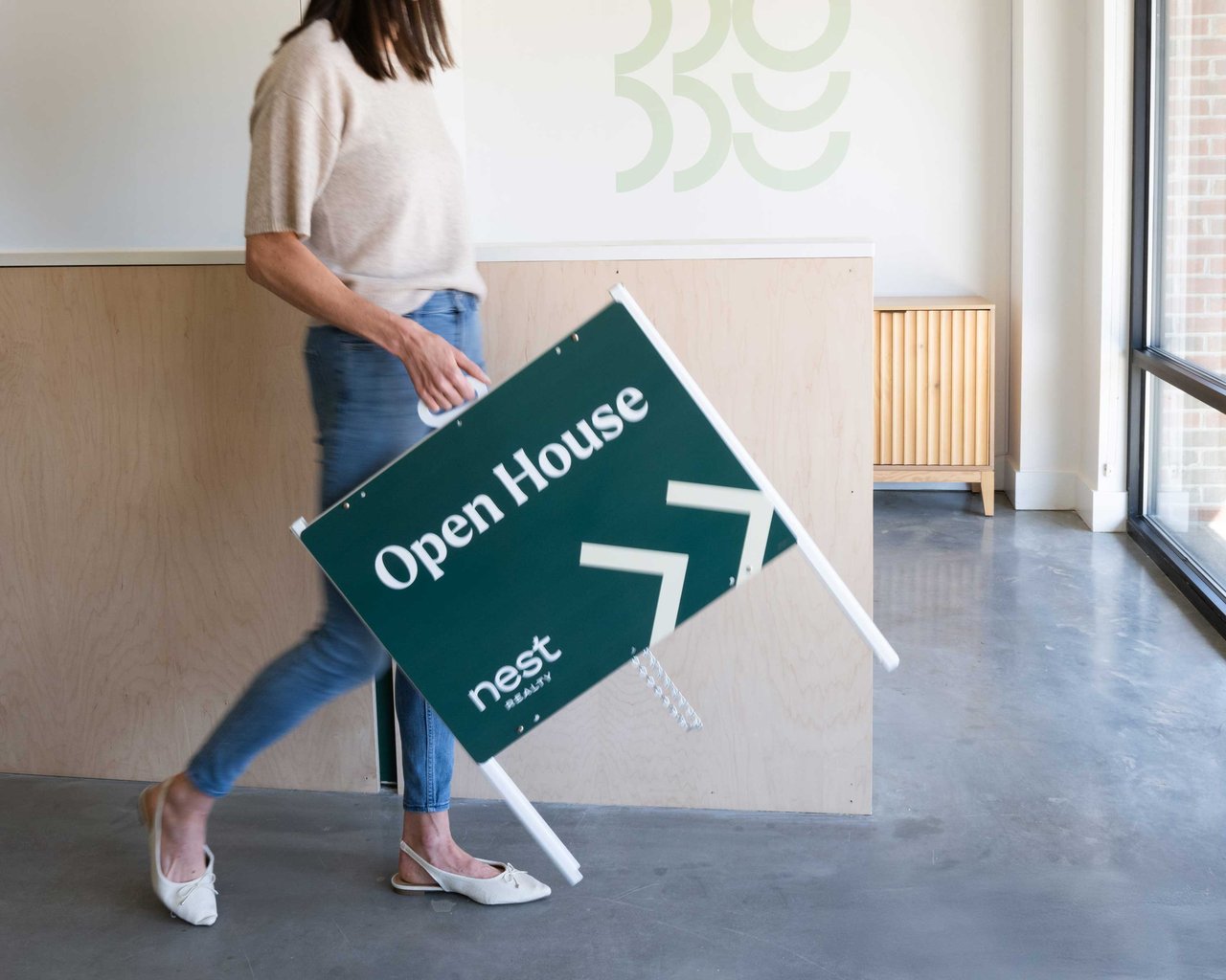 a Nest agent walking with an Open House sign