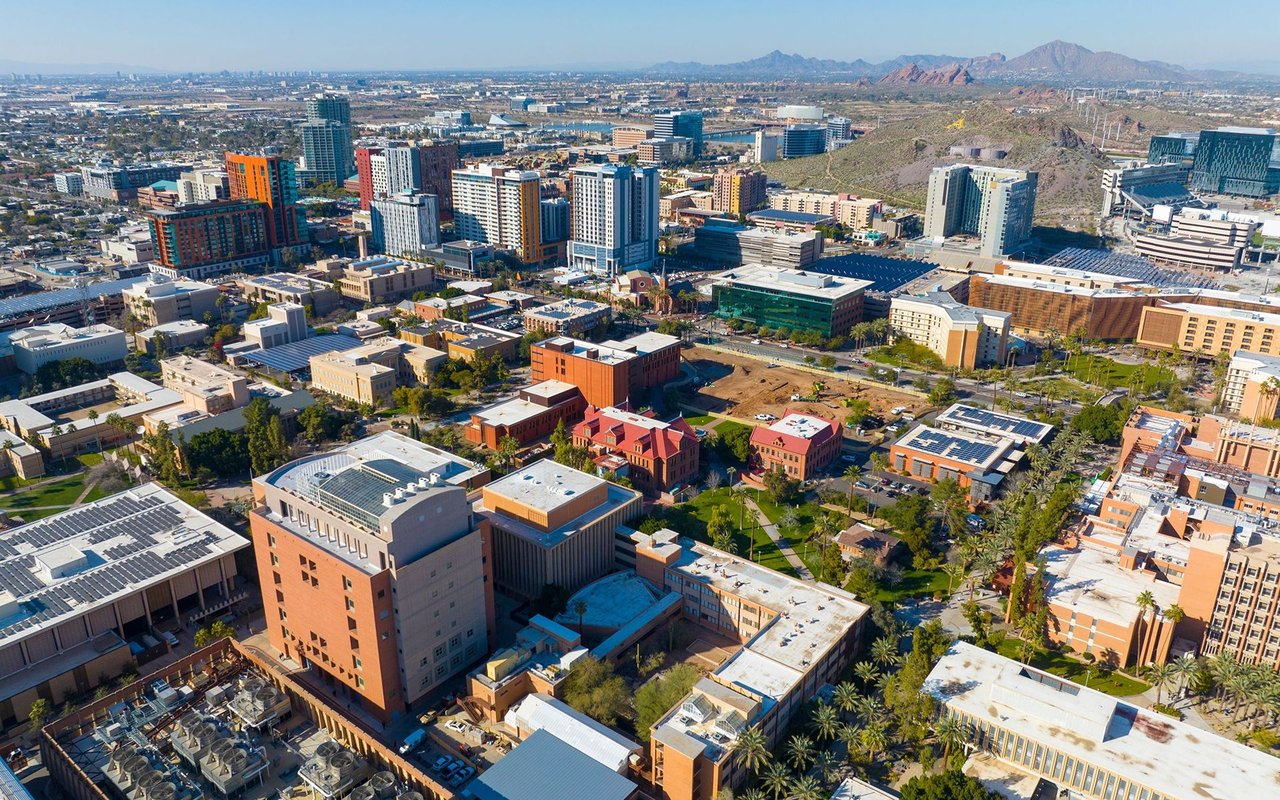 Downtown Tempe from above, with modern buildings and desert mountains beyond.