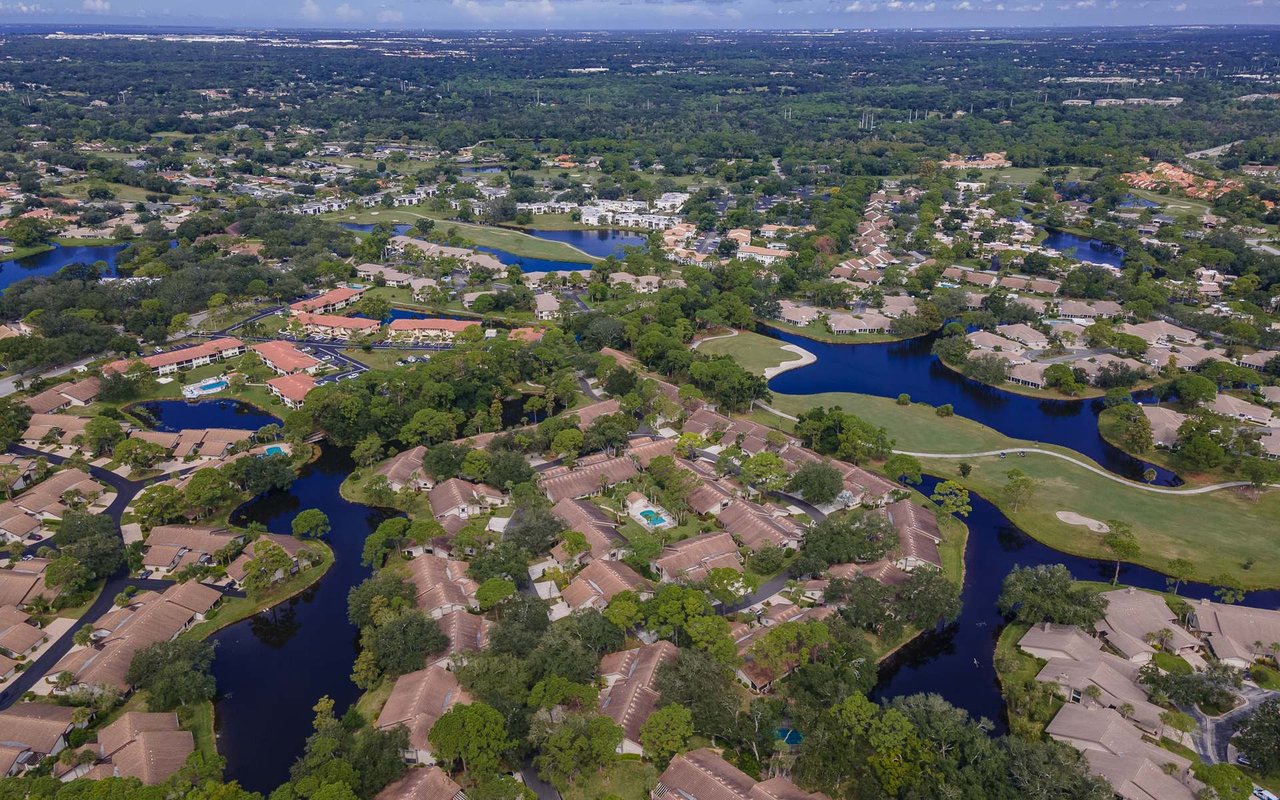 Aerial view of The Meadows, with homes, winding lakes, and golf course fairways.
