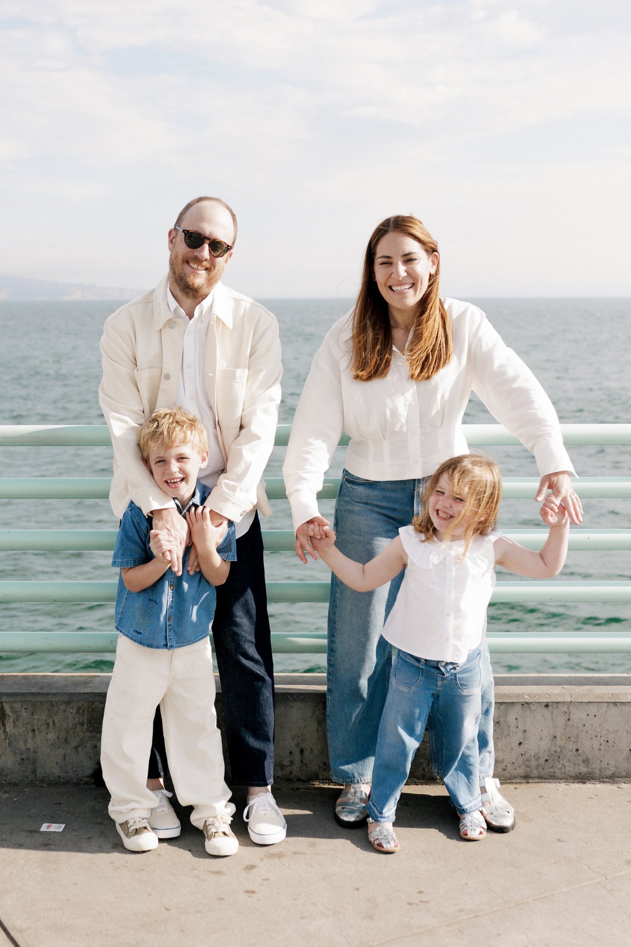Smiling family standing together beside the ocean