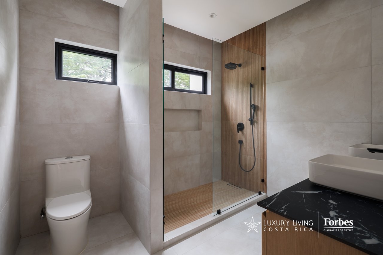 Modern bathroom with a glass walk-in shower and wood-slat accent wall.