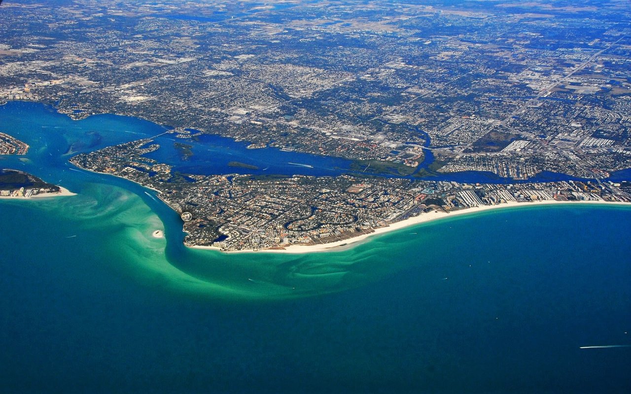 An aerial view of Siesta Key with skyscrapers and a harbor