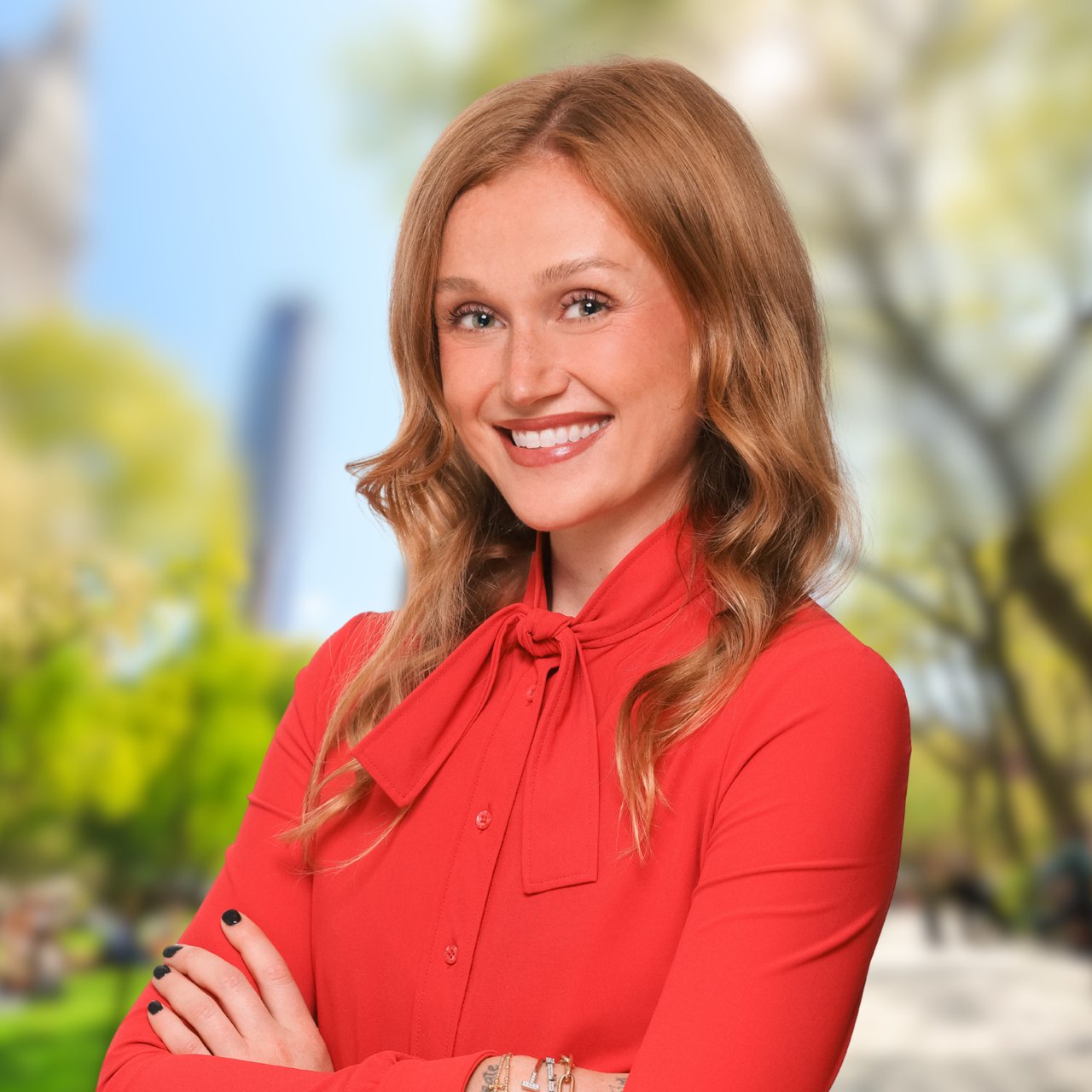 Georgia Fife smiles in a red blouse with her arms crossed.