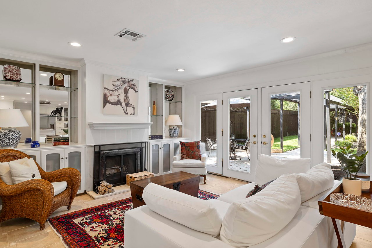 Living room with a fireplace and wicker armchair, Tarrytown, Austin.