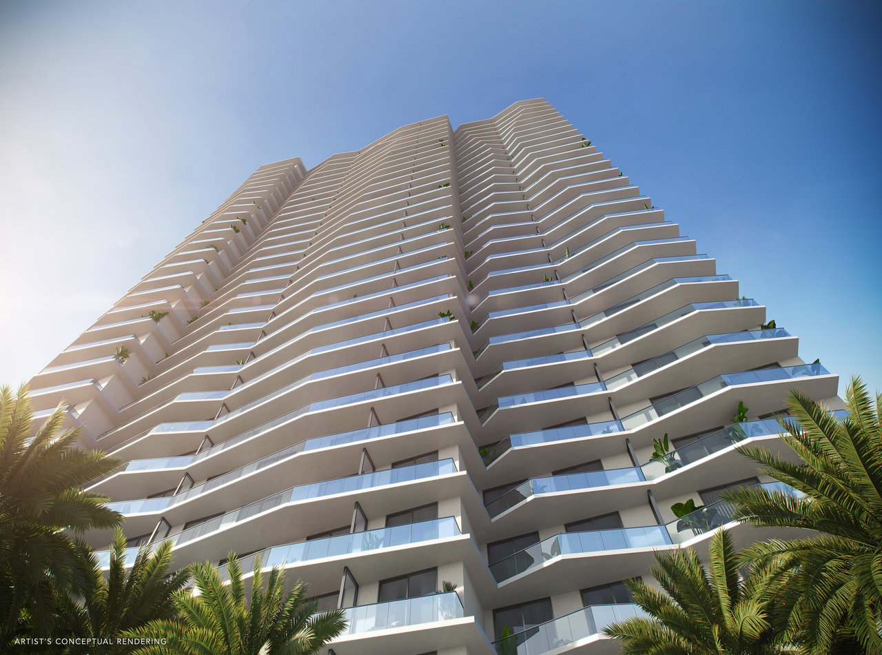 Modern high-rise tower with angular balconies and glass railings, framed by palm trees.
