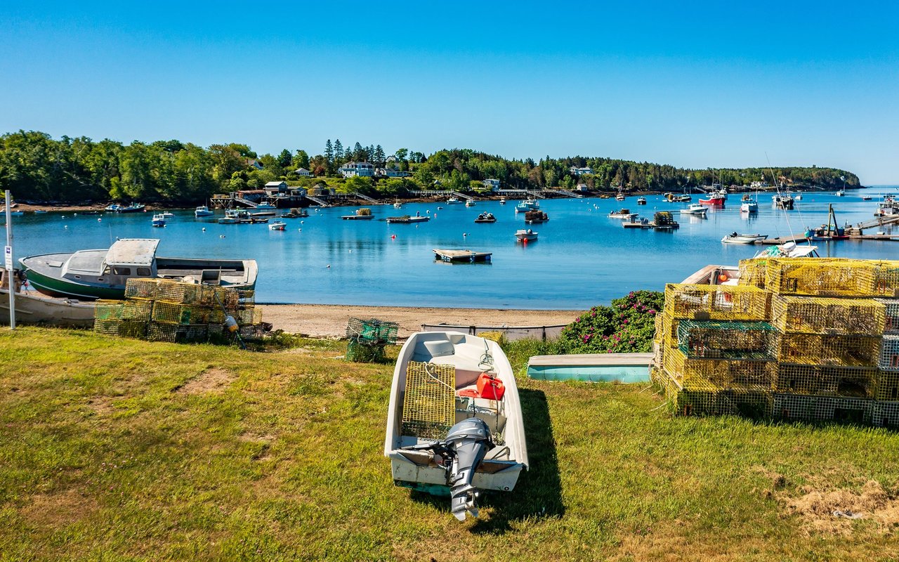 Harpswell harbor with lobster traps, small boats, and a wooded shoreline.