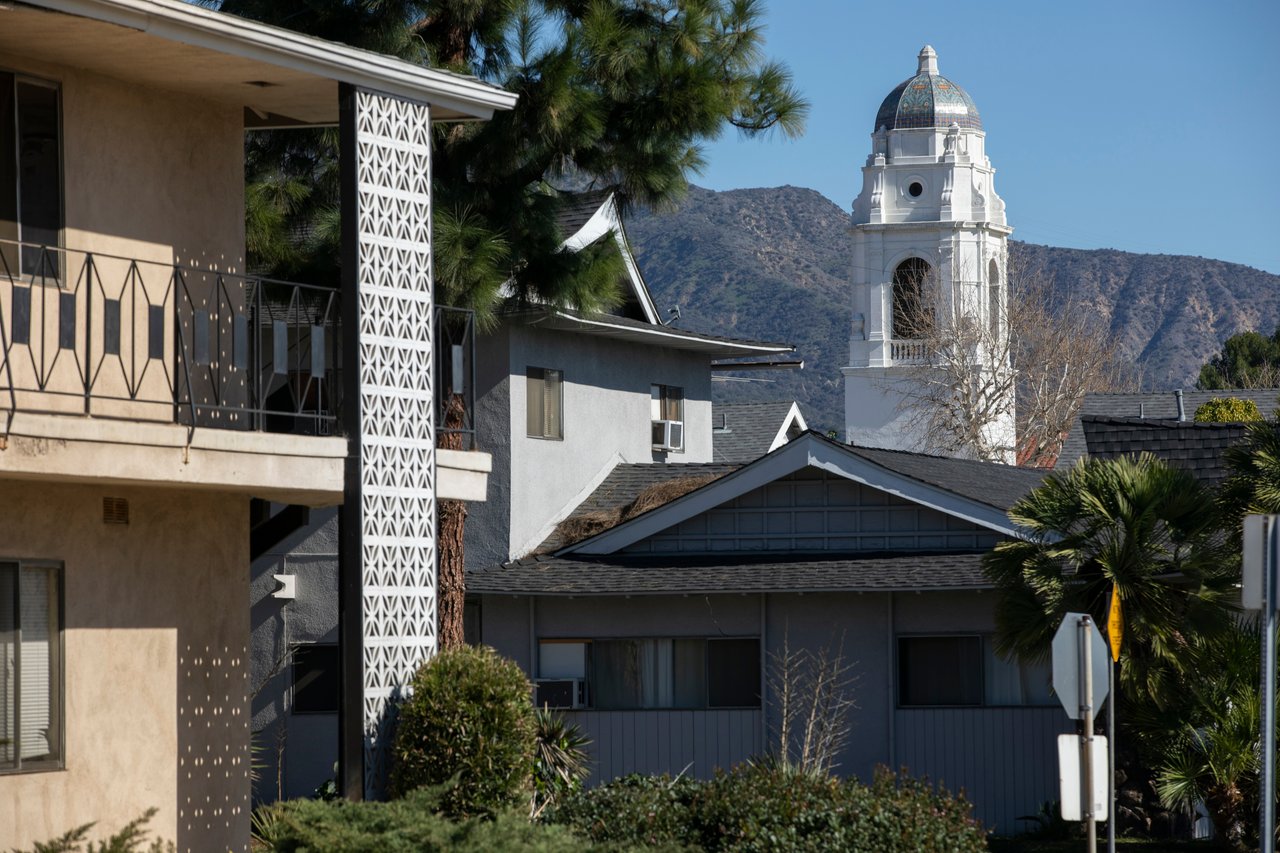Monrovia neighborhood homes with a white domed tower and mountains behind them.