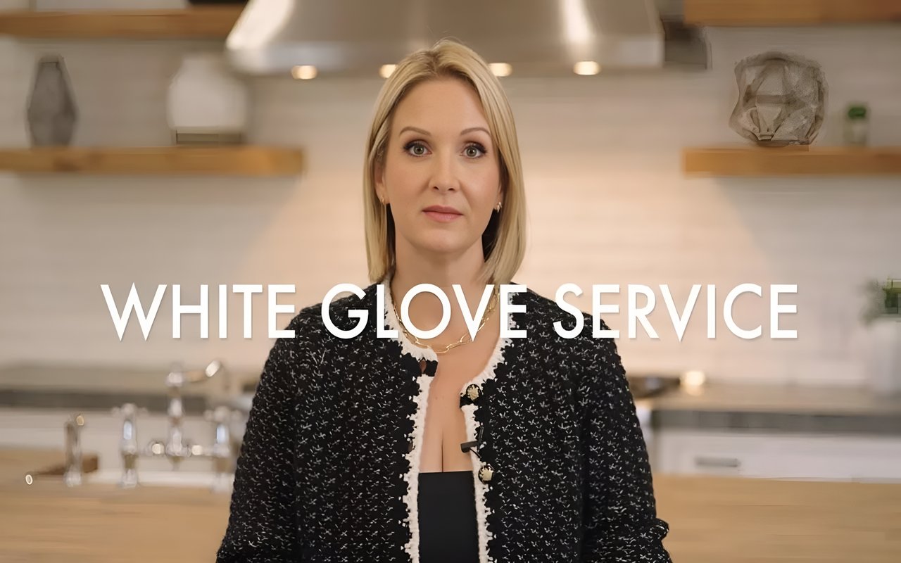  A professional photo of Annie Clougherty in a black and white tweed jacket, with a modern kitchen in the background.